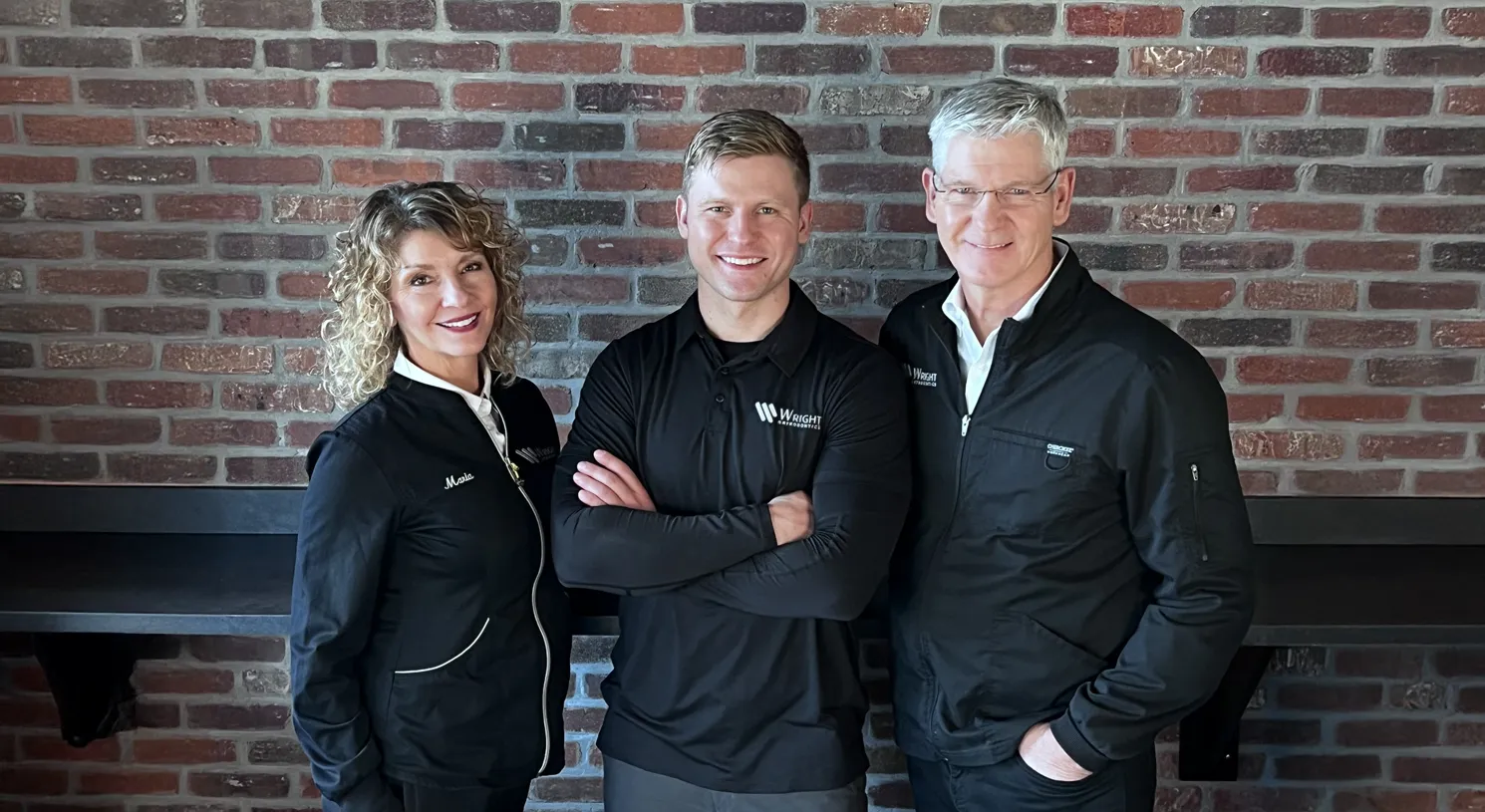 Dr. Daniel Wright, Dr. Randy Wright, and Maria from Wright Orthodontics, standing inside the clinic to welcome patients