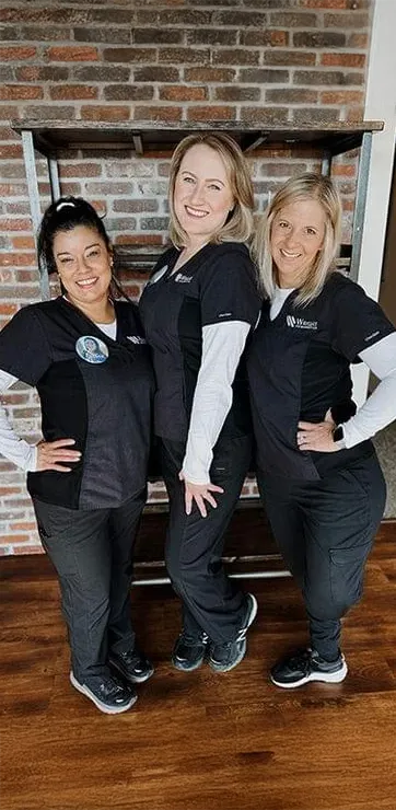 Staff members of Wright Orthodontics in the lobby of the clinic ready to welcome patients